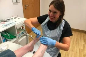 Sidmouth Podiatrist Sue Pyle working on feet at the clinic