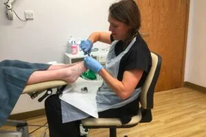 Sidmouth Podiatrist Sue Pyle cutting toenails